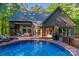 Backyard swimming pool with wooden deck, patio furniture, and lush green landscaping at 131 Sierra Woods Dr, Troutman, NC 28166