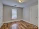 A bright bedroom features hardwood floors, a window, and two doors at 1324 E 35Th St, Charlotte, NC 28205