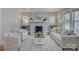 A cozy living room with a painted brick fireplace, hardwood floors, and bright, neutral furnishings at 1324 E 35Th St, Charlotte, NC 28205