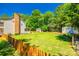 Spacious grassy backyard with wooden fence, mature trees, pool house and storage shed at 1355 Woodrun Ct, Rock Hill, SC 29732