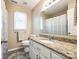Bright bathroom featuring granite countertops, white cabinetry, and a window with natural light at 1355 Woodrun Ct, Rock Hill, SC 29732