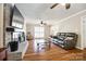 Comfortable living room showcasing a brick fireplace, hardwood floors, ceiling fan, and ample natural light at 1355 Woodrun Ct, Rock Hill, SC 29732