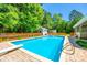 Inviting backyard pool with diving board, surrounded by brick pavers, wooden fence, and mature trees at 1355 Woodrun Ct, Rock Hill, SC 29732