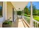 Relaxing covered porch with a comfortable bench, white railings, and views of the lush green lawn and trees at 1355 Woodrun Ct, Rock Hill, SC 29732