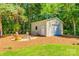 Backyard shed with roll-up door, fire pit and seating area in a landscaped yard at 1355 Woodrun Ct, Rock Hill, SC 29732