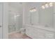 A bright bathroom featuring double sinks, white cabinets, and glass enclosed shower with tiled floor at 15131 Oleander Dr, Charlotte, NC 28278