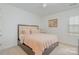 A cozy bedroom painted with white walls, featuring a plush bed and a large, bright window at 15131 Oleander Dr, Charlotte, NC 28278