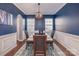 Formal dining room with dark blue walls, elegant chandelier, and hardwood flooring at 15131 Oleander Dr, Charlotte, NC 28278