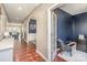 Inviting entryway with hardwood floors leads to a cozy office with navy accent wall and chair at 15131 Oleander Dr, Charlotte, NC 28278
