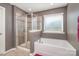 A well-lit bathroom featuring a glass shower and separate tub under a bright window at 15131 Oleander Dr, Charlotte, NC 28278