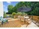 Inviting wooden deck featuring an umbrella-shaded dining set, perfect for outdoor gatherings and relaxation at 1622 Candlewood Ridge Ln, Matthews, NC 28105
