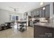 Well-lit kitchen with stainless steel appliances, an island, and a view to the dining area and outdoor patio at 1622 Candlewood Ridge Ln, Matthews, NC 28105