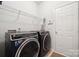 Functional laundry room with modern washer and dryer, storage shelves, and convenient access to the outdoors at 1622 Candlewood Ridge Ln, Matthews, NC 28105