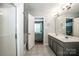 Bright bathroom showing a double sink vanity and doorway leading to a bedroom at 17307 Villanova Rd, Huntersville, NC 28078