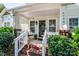 Close-up of the inviting front porch with brick steps, white railings, and a cozy seating area at 17307 Villanova Rd, Huntersville, NC 28078