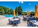 Community pool area with ample seating under yellow umbrellas, perfect for enjoying sunny days at 17307 Villanova Rd, Huntersville, NC 28078