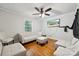 Inviting living room features hardwood floors, a ceiling fan, and modern white sofas with television for entertainment at 1917 Tom Sadler Rd, Charlotte, NC 28214