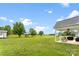 Expansive backyard featuring a lush lawn, mature trees, and a covered patio with outdoor furniture at 210 Dorothy Dr, China Grove, NC 28023