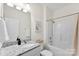 Well-lit bathroom featuring a granite countertop vanity and a shower-tub combination at 210 Dorothy Dr, China Grove, NC 28023
