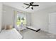 Bright bedroom featuring two twin beds, white walls, a ceiling fan, and a window overlooking the yard at 210 Dorothy Dr, China Grove, NC 28023