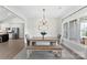 Bright dining room with a modern chandelier, wood table, bench seating, and large windows at 210 Dorothy Dr, China Grove, NC 28023