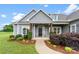 Inviting front porch with stone accents, decorative shrubs, and a black front door with a wreath at 210 Dorothy Dr, China Grove, NC 28023