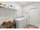 The laundry room features white washer and dryer, shelving and a door to the outside at 210 Dorothy Dr, China Grove, NC 28023