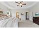 A spacious main bedroom featuring a tray ceiling, ceiling fan and ensuite bathroom at 210 Dorothy Dr, China Grove, NC 28023