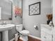 Well-lit bathroom with a pedestal sink, modern fixtures, and decorative wall art at 234 Ascot Run Way, Fort Mill, SC 29715