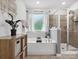 Bright bathroom showcasing a tub with tiled walls, glass-enclosed shower, and decorative accents at 234 Ascot Run Way, Fort Mill, SC 29715