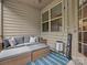 Inviting screened-in porch with a wicker sofa, striped rug, creating a cozy outdoor living space at 234 Ascot Run Way, Fort Mill, SC 29715
