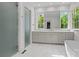 Bathroom featuring dual sinks, marble tile floors, walk-in shower, soaking tub and large window at 2710 Briarcliff Pl, Charlotte, NC 28207