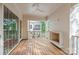 Covered porch features wood flooring, white brick fireplace, and ceiling fan at 2710 Briarcliff Pl, Charlotte, NC 28207