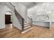 Elegant foyer featuring a staircase with wooden steps and black railings, and a modern, bright kitchen at 2710 Briarcliff Pl, Charlotte, NC 28207