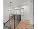 Hallway with hardwood floors, stairs and modern light fixture at 2710 Briarcliff Pl, Charlotte, NC 28207
