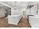 A modern kitchen featuring a large island with sink, white cabinets, stainless steel appliances, and hardwood floors at 2710 Briarcliff Pl, Charlotte, NC 28207
