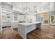 Open kitchen layout with a large island, stainless steel appliances, hardwood floors, and access to outdoor area at 2710 Briarcliff Pl, Charlotte, NC 28207