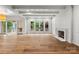 Bright living room with hardwood floors, a fireplace, and glass doors leading to an outdoor space at 2710 Briarcliff Pl, Charlotte, NC 28207