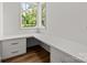 Bright office space with white built-in desk and storage, hardwood floors, and a large window at 2710 Briarcliff Pl, Charlotte, NC 28207