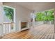 Wide porch features wood floor, brick fireplace, and outdoor ceiling fan at 2710 Briarcliff Pl, Charlotte, NC 28207