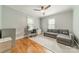 Comfortable bedroom featuring hardwood floors, ceiling fan, work space and grey sofa at 2915 Wesley Ave, Charlotte, NC 28205
