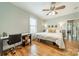 Cozy bedroom with hardwood floors, ceiling fan, desk, and a comfortable bed with pillows at 2915 Wesley Ave, Charlotte, NC 28205