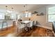 Cozy dining room with hardwood floors, white chairs, modern lighting, and sunlit windows at 2915 Wesley Ave, Charlotte, NC 28205