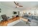 Modern living room with hardwood floors, ceiling fan, sectional sofa, TV, and view to the kitchen at 2915 Wesley Ave, Charlotte, NC 28205
