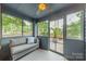 Cozy screened porch with comfortable seating, ceiling fan, and views of the landscaped backyard at 2915 Wesley Ave, Charlotte, NC 28205