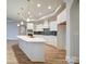 Open kitchen with stainless appliances, large island, tile backsplash, and modern lighting at 3069 Founding Fathers Dr, Gastonia, NC 28056
