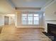 Open-concept living room boasts luxury vinyl plank flooring, a fireplace, and a wall of windows at 3069 Founding Fathers Dr, Gastonia, NC 28056