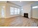 Bright living room featuring a fireplace, large windows, and wood-look flooring at 3069 Founding Fathers Dr, Gastonia, NC 28056