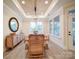 Bright dining room features modern lighting fixture and an oval mirror against wood floors and many windows at 3089 Founding Fathers Dr, Gastonia, NC 28056