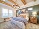 Charming main bedroom featuring panel accent wall, wood beam ceiling, and large windows for natural light at 3089 Founding Fathers Dr, Gastonia, NC 28056